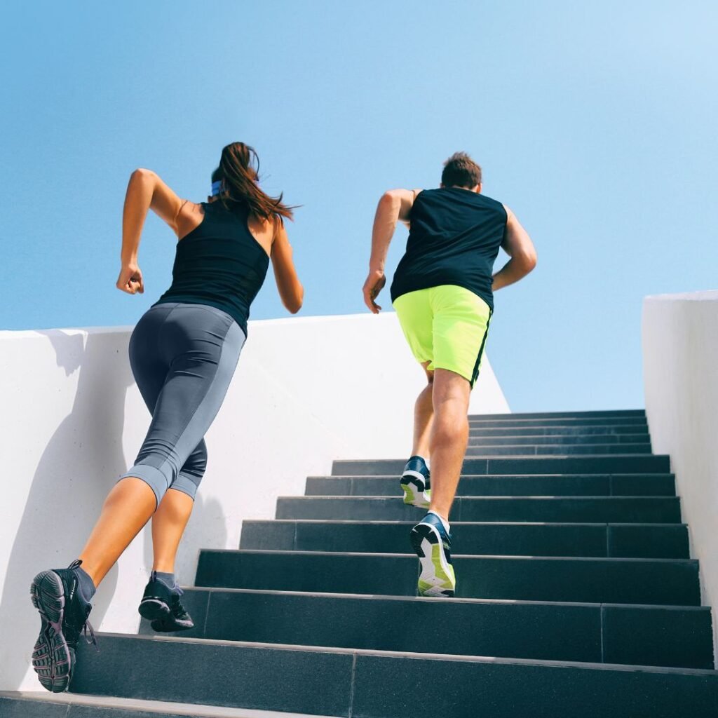 Dos personas haciendo ejercicio al aire libre subiendo escaleras, representando actividad física intensa como estrategia para mejorar la salud y aumentar la longevidad