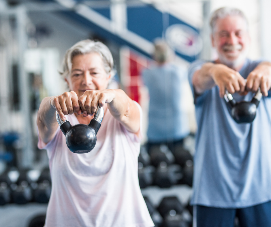 Personas mayores entrenando con pesas rusas en el gimnasio para mejorar fuerza y salud.