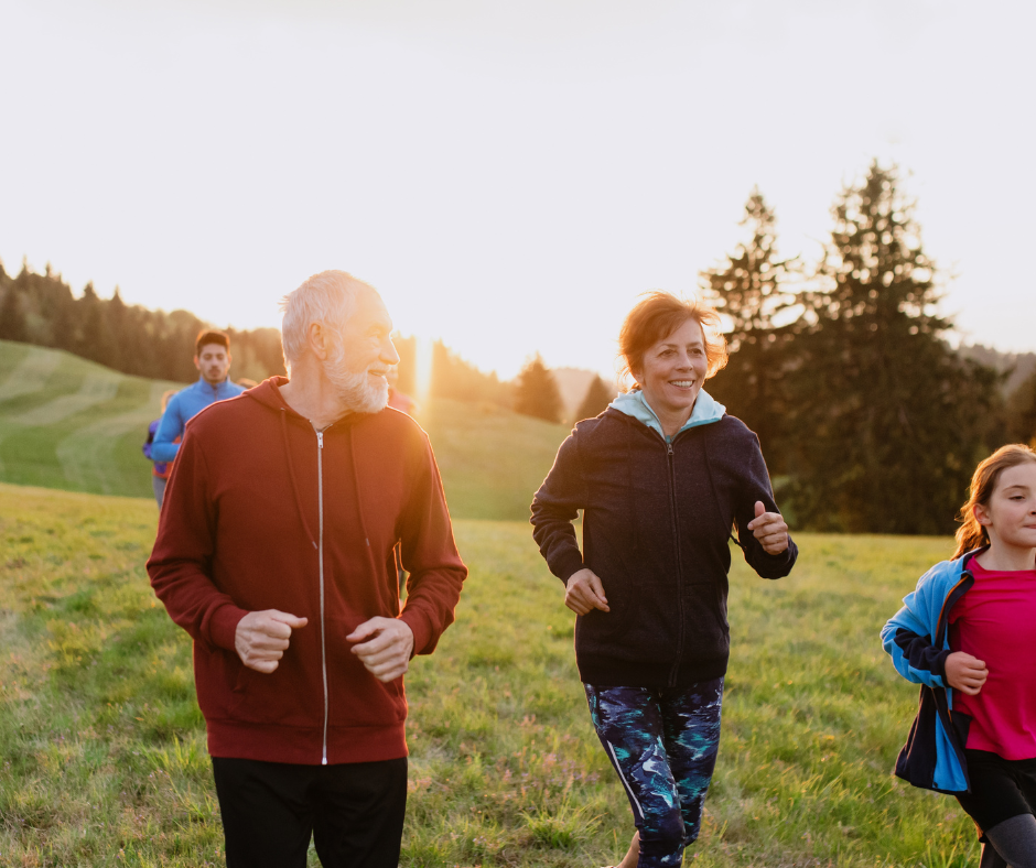 Familia de diferentes generaciones corriendo al aire libre al atardecer, representando hábitos activos y vínculos sociales saludables, clave en las Zonas Azules.