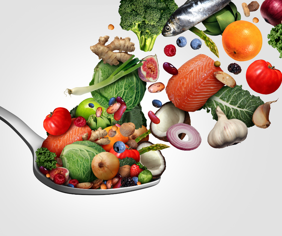 Alimentos saludables para la longevidad: salmón, frutas, vegetales, frutos secos y superalimentos sobre una cuchara metálica.

