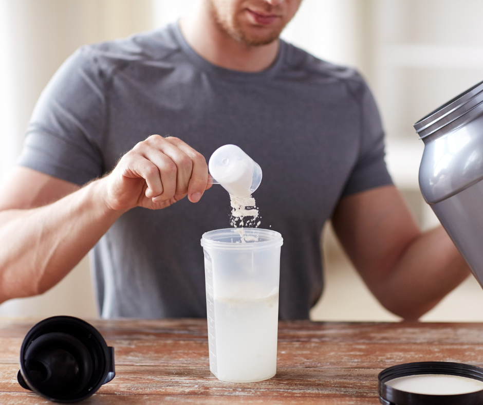 Hombre preparando batido de creatina en shaker transparente, vertiendo suplemento en polvo para mejorar fuerza y recuperación muscular.