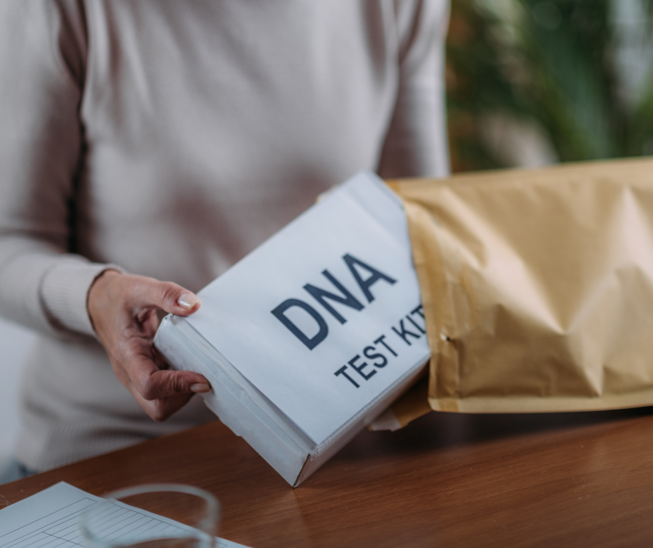Persona sacando un kit de prueba de ADN de un sobre en casa para realizar un autotest genético.