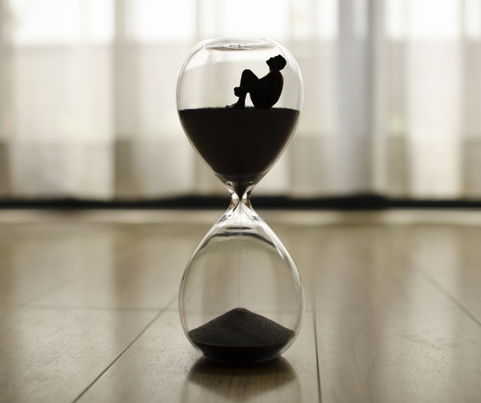 Persona atrapada en un reloj de arena simbolizando la presión del tiempo y el impacto del estrés crónico en la vida diaria.