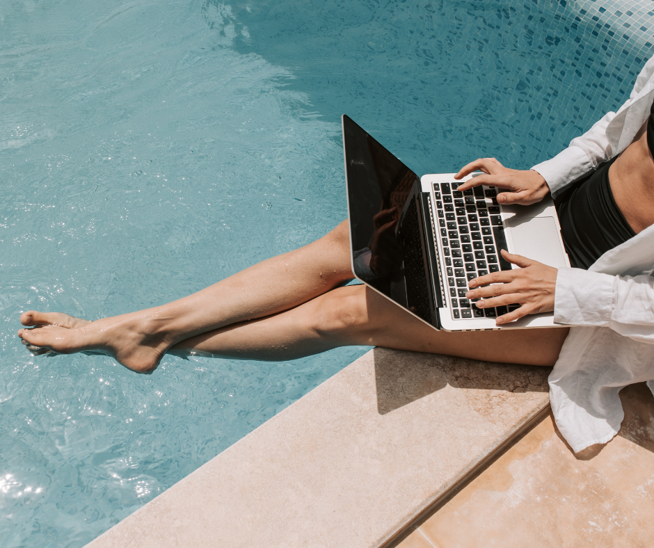 Persona trabajando con laptop junto a una piscina, combinando trabajo remoto con tiempo de ocio y calidad de vida.