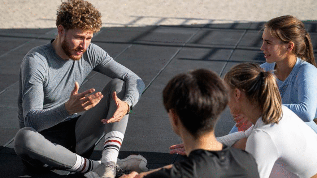 Entrenador deportivo hablando con jugadores sobre salud mental, motivación y recuperación emocional en el deporte
